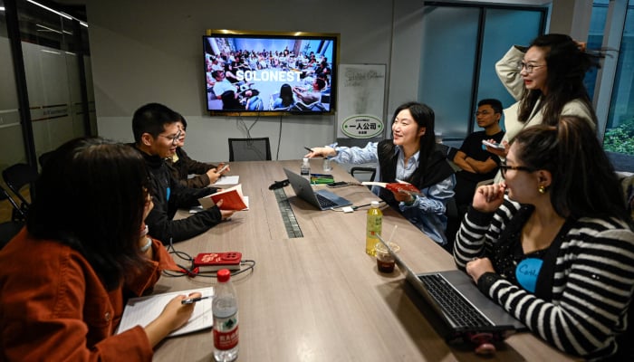 The photo taken on April 12, 2026 shows founder of one-person company SoloNest Karen Dai (centre) sharing her experience with participants during a coffee chat at a conference room in Shanghai, China. — AFP