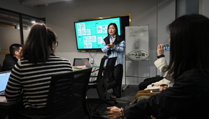 The photo taken on April 12, 2026 shows founder of one-person company SoloNest Karen Dai sharing her experience with participants during a coffee chat at a conference room in Shanghai, China. — AFP