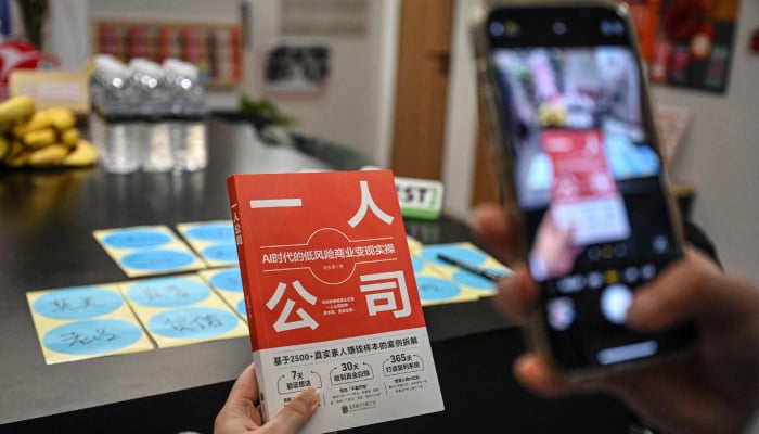 The photo taken on April 12, 2026 shows founder of one-person company SoloNest Karen Dai taking a photo of her new book One Person Company at a conference room in Shanghai, China. — AFP