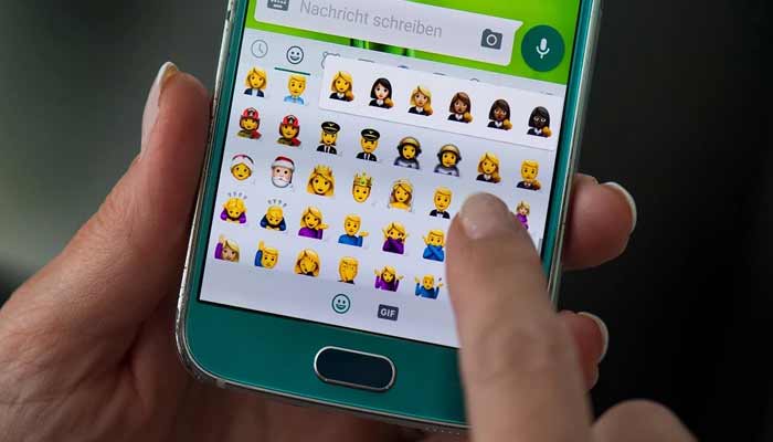 A person uses emojis in their chat while using WhatsApp on a smartphone in this unated image. — AFP/File