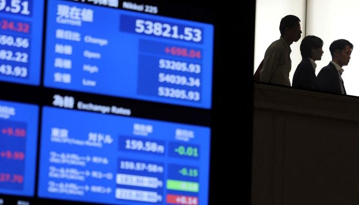 Visitors walk near screens displaying current market information at Japan Exchange Groups Tokyo Stock Exchange in Tokyo, Japan, April 6, 2026. — Reuters