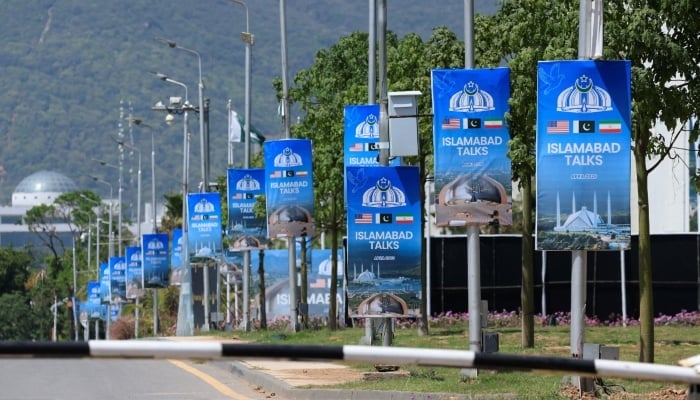 Hoardings are mounted on lamp posts, as Pakistan prepares to host the US and Iran for a possible second phase of talks in Islamabad, April 20, 2026. — Reuters