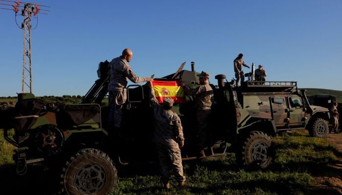 Spanish soldiers place a Spanish flag on a vehicle during Exercise Dynamic Mariner 25 military drill training, which involves naval forces from several Nato members, at Retin beach, in the Atlantic Ocean, in Barbate, Spain, March 28, 2025. — Reuters