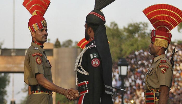 A Pakistani Ranger, center, and an Indian Border Security Force (BSF) officer, left, shake hands during the daily parade at the Pakistan-India joint check-post at Wagah border, Pakistan. — Reuters/File