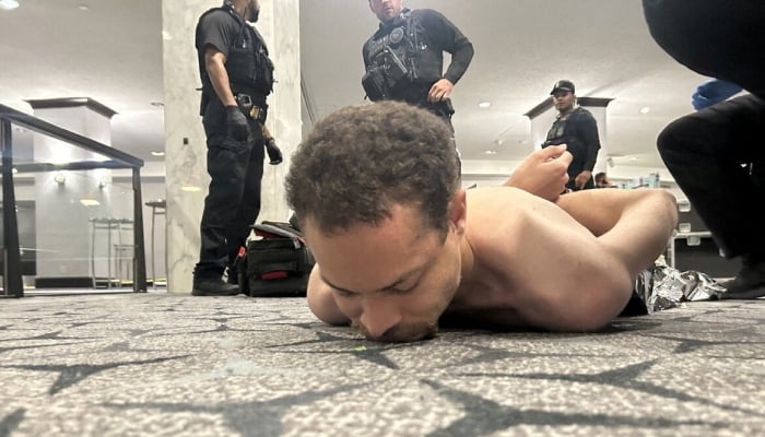 Law enforcement personnel detain a person of interest, after US President Donald Trump and first lady Melania Trump were rushed out of the White House Correspondents Association dinner by Secret Service agents when a man armed with a shotgun tried to breach security, officials said, in Washington, DC, US April 25, 2026. — Reuters