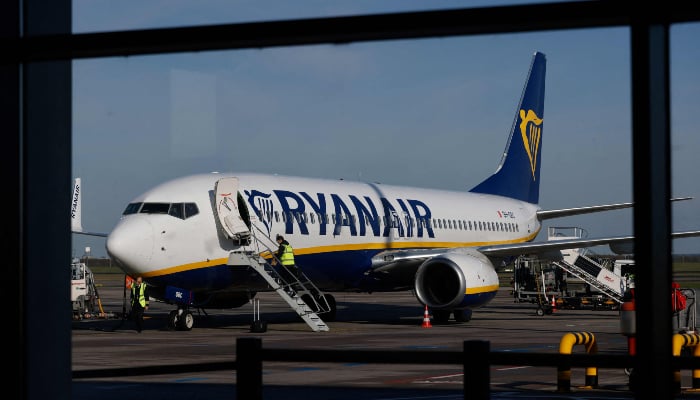 An aircraft of low-cost Irish airline Ryanair is prepared pre-flight at the Berlin-Brandenburg airport in Schoenefeld near Berlin, on April 4, 2024. — AFP