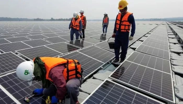 A worker kneels by one of the solar cell panels over the water surface of Sirindhorn Dam in Ubon Ratchathani, Thailand, April 8, 2021.— Reuters
