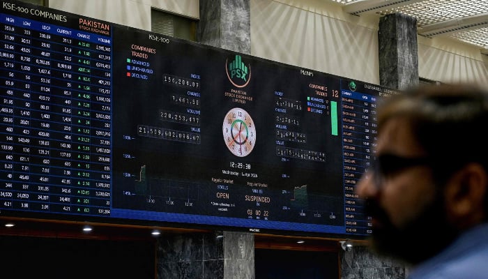 A stockbroker looks at share prices on a digital board during a trading session at the Pakistan Stock Exchange (PSX) in Karachi on April 1, 2026. — AFP