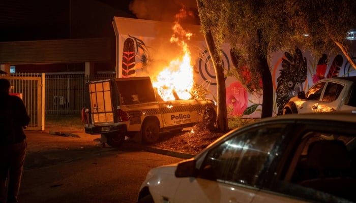 A police vehicle burns after community members clashed with police outside Alice Springs Hospital, where a 47-year-old man arrested in connection with the alleged killing of five-year-old Kumanjayi Little Baby was taken, in Alice Springs, Australia, April 30, 2026. — Reuters