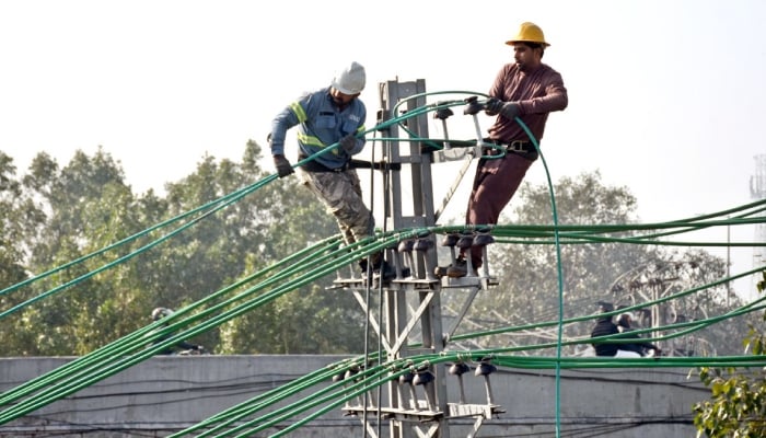 Lesco workers repairing and laying new electric wires on electricity poles to restore electricity on Ferozepur Road in Lahore, February 10, 2026. — APP