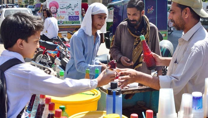 Students buying sweet crushed ice form a vendor during a hot day in Rawalpindi, on April 27, 2026. — Online