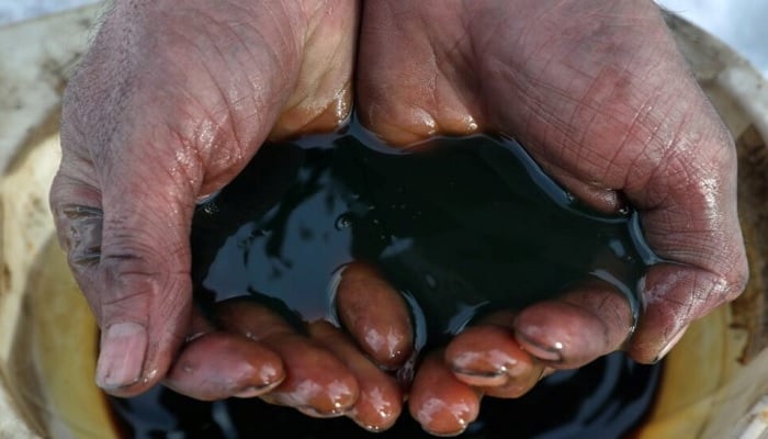 An employee demonstrates a sample of crude oil in the Yarakta Oil Field, owned by Irkutsk Oil Company (INK), in Irkutsk Region, Russia, in this picture illustration taken March 11, 2019. — Reuters