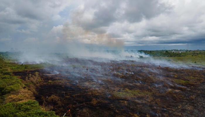 An aerial view of a landscape showing flames of a wildfire in Indonesia. — AFP