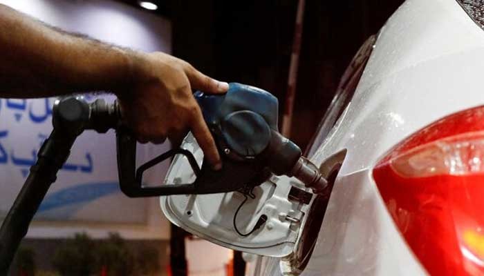 A worker holds a fuel nozzle to fill fuel in a car, after the government announced the increase of petrol and diesel prices, at a petrol station in Karachi on September 16, 2023. — Reuters