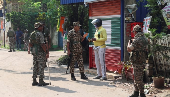 Members of security forces stop a delivery personnel as they stand guard along a road leading to the site where an aide of Suvendu Adhikari, a leader of Bharatiya Janata Party (BJP) in West Bengal state, was shot dead days after the BJP secured a majority in the state assembly elections, in North 24 Parganas, on the outskirts of Kolkata, India, May 7, 2026. — Reuters