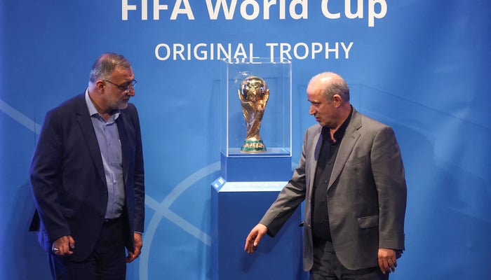 President of Iran Football Federation Mehdi Taj and Mayor of Tehran Alireza Zakani stand next to the FIFA World Cup Trophy during an unveiling ceremony in Tehran, Iran September 1, 2022. – Reuters