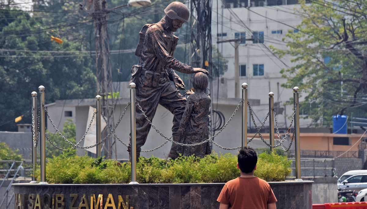 A young boy looking an army soldier sculpture displayed in round about of Panj Sarki area in the city as Pakistan is commemorating the first anniversary of Operation Bunyan-un-Marsoos. — Online