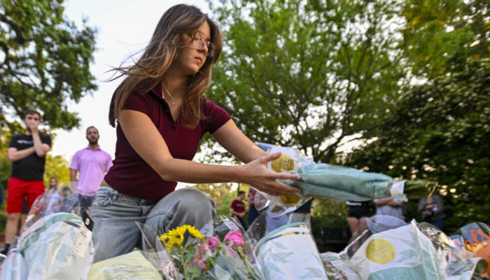 A woman places flowers at a vigil near the scene of a deadly shooting at Florida State University in 2025. — AFP