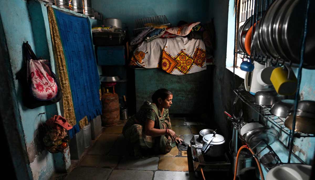 Hasumati Parmar, a policyholder of a heat insurance scheme, preparing a meal inside her house in Ahmedabad.— AFP