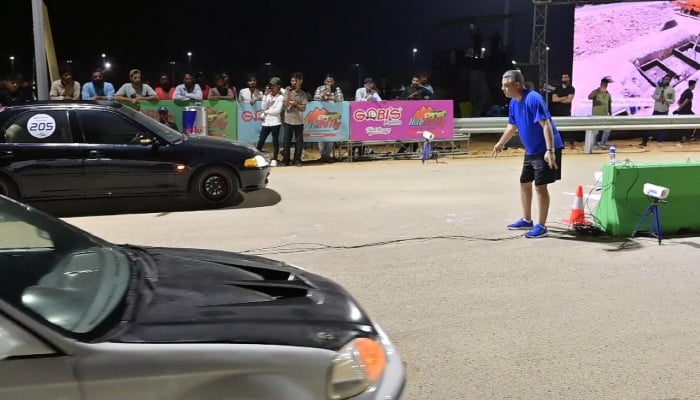 Cars line up during a night race at a newly floodlit motorsports track in Karachi. — Reporter