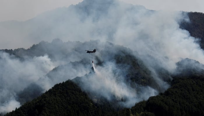 A helicopter conducts firefighting operations as wildfires continue in Otsuchi, Iwate Prefecture, Japan, April 26, 2026. — Reuters