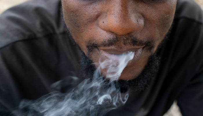 A drug addict smokes a joint in Abuja on February 24, 2026. — AFP
