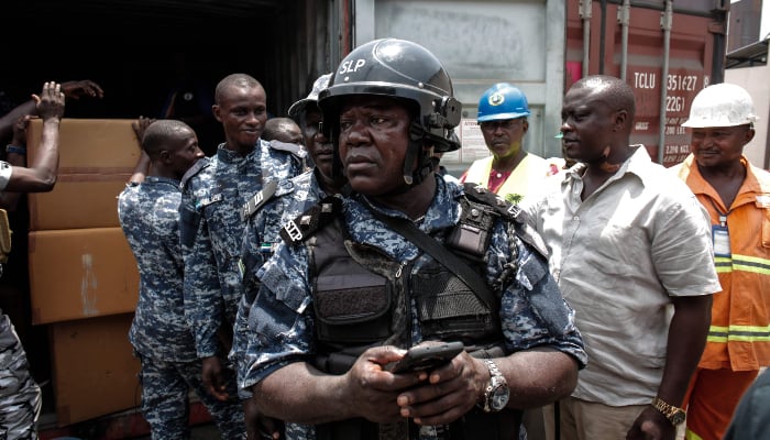 A member of the Transnational Organised Crime Unit (TOCU), a specialised unit of the Sierra Leone Police (SLP) dedicated to combating drug trafficking, organised crime and cross-border criminal activities, looks on after opening one of the four seized containers containing Tapentadadol (Tramadol) tablets and capsules originating from India at the Freetown Terminal in Freetown, on March 27, 2026. — AFP