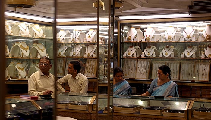 Employees sit behind counters as they wait for customers inside a jewellery store in the old quarters of Delhi, India, May 11, 2026. — Reuters