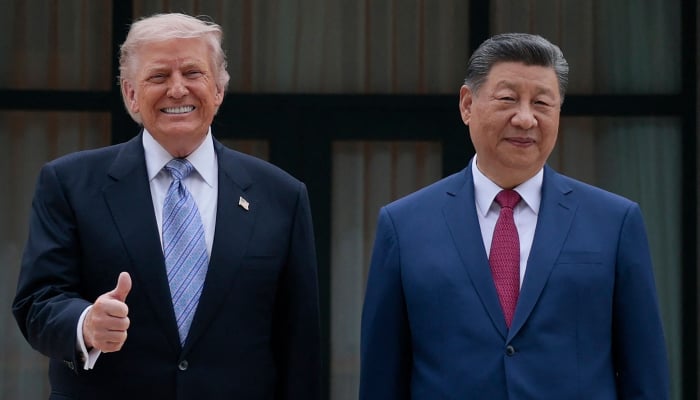 US President Donald Trump (L) poses for photos with Chinas President Xi Jinping during a visit to Zhongnanhai Garden in Beijing on May 15, 2026. — AFP