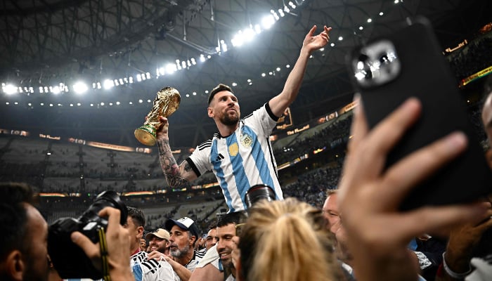 Argentinas captain and forward #10 Lionel Messi (R) holds the Fifa World Cup Trophy following the trophy ceremony after Argentina won the Qatar 2022 World Cup final football match between Argentina and France at Lusail Stadium in Lusail, north of Doha on December 18, 2022. — AFP