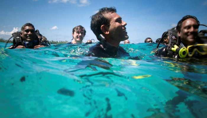 Maldivian President Mohamed Nasheed (C) and other cabinet members attend the first underwater cabinet meeting in the Maldives. — Reuters/File