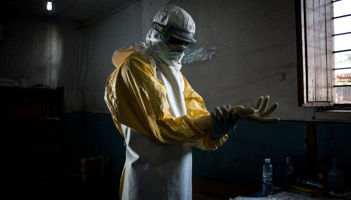 A health worker puts on his personal protective equipment (PPE) before entering the red zone of a MSF (Doctors Without Borders) supported Ebola Treatment Centre (ETC), on November 6, 2018, in Bunia, Democratic Republic of the Congo. — AFP