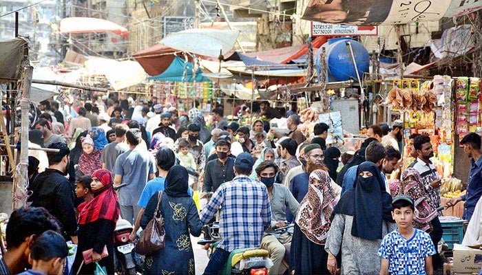 This undated image shows a large number of people throng Karachis Ranchor Line Sabzi Bazaar to purchase essential items. — APP/File