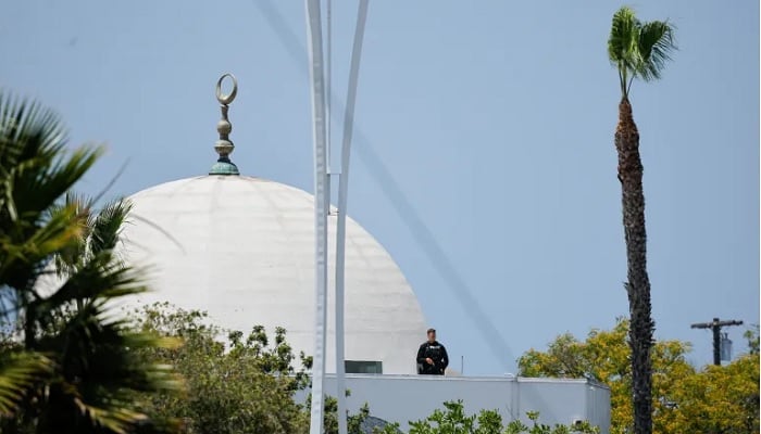A police officer stands guard as emergency personnel respond to a reported active shooter situation at the Islamic Centre of San Diego in San Diego, California, US, May 18, 2026. — Reuters