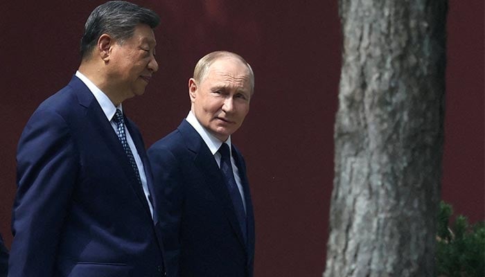 Chinese President Xi Jinping and Russian President Vladimir Putin walk at the personal residence of the Chinese leader Zhongnanhai in Beijing, China September 2, 2025. — Reuters