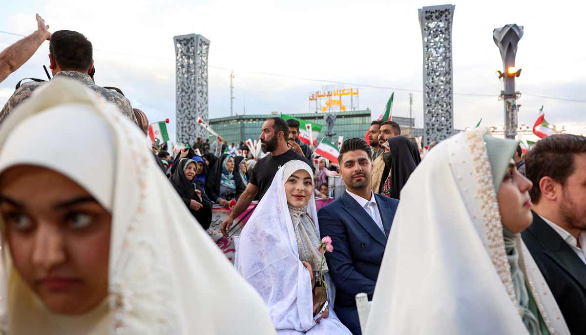 A bride and groom couple attends a public mass wedding ceremony at Imam Hossein Square in Tehran on May 18, 2026.— AFP