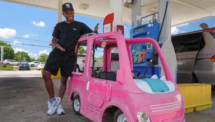 Mali Hightower, 30, poses with what he describes as a self-created gas saver, a pink Power Wheels Barbie Dream Camper, at a gas station in Ellenwood, Georgia, US, May 18, 2026. — Reuters