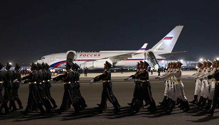 In this pool photograph distributed by the Russian state agency Sputnik, Chinese honour guards march past the airplane carrying Russias President Vladimir Putin upon his arrival at Beijing Capital Airport in Beijing late on May 19, 2026. — AFP