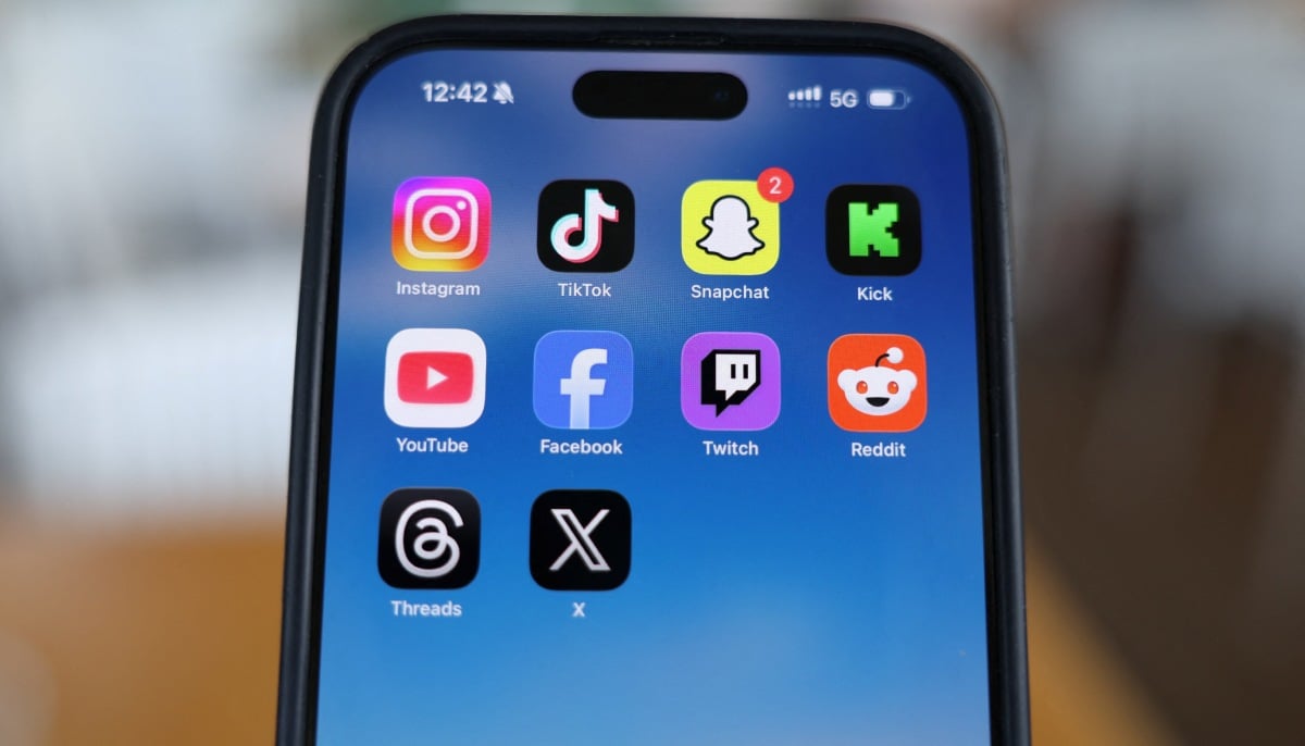Instagram, TikTok, Snapchat, Kick, YouTube, Facebook, Twitch, Reddit, Threads and X applications are displayed on a mobile phone, in this picture illustration taken on December 9, 2025. — Reuters
