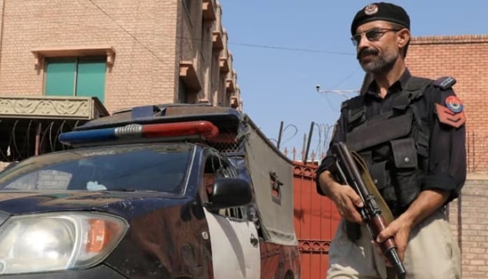 A Balochistan police officer stands guard near his vehicle. — Reuters/File