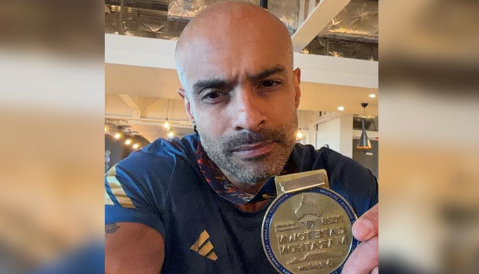 Pakistani runner Faisal Shafi poses for a photo with his medal. — reporter