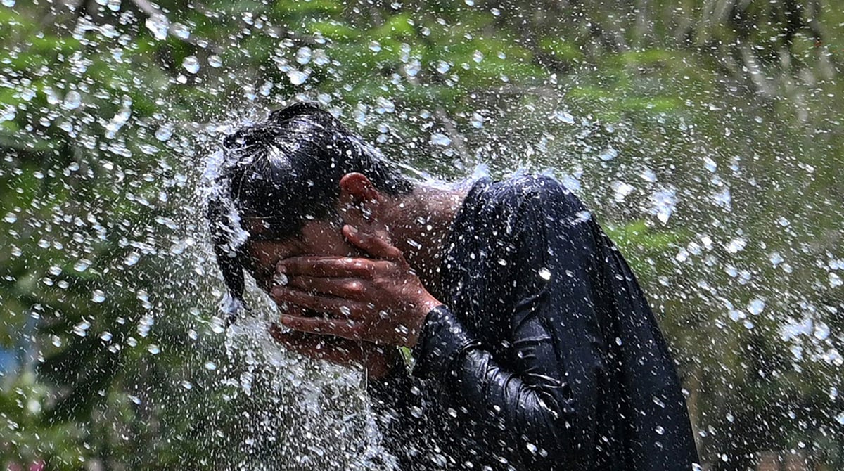 A man cools off on a hot summer day, at a park in Karachi on May 12, 2026. — AFP