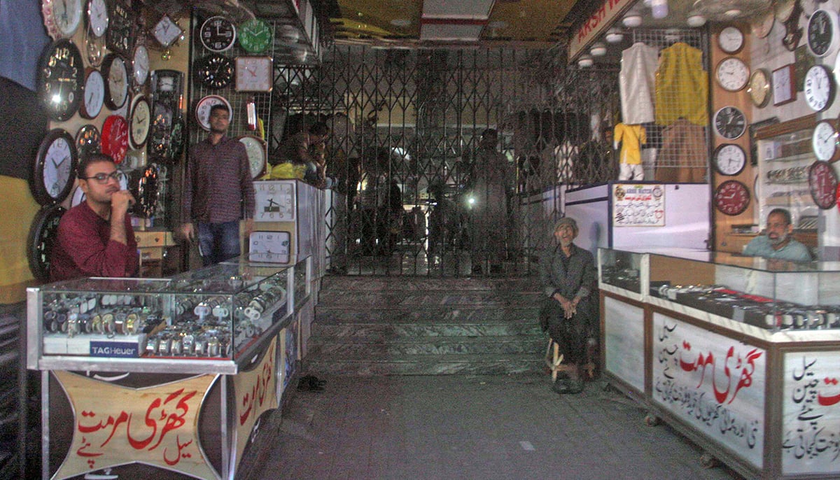 Traders await power at their shops in Sadr area in Karachi. — Online