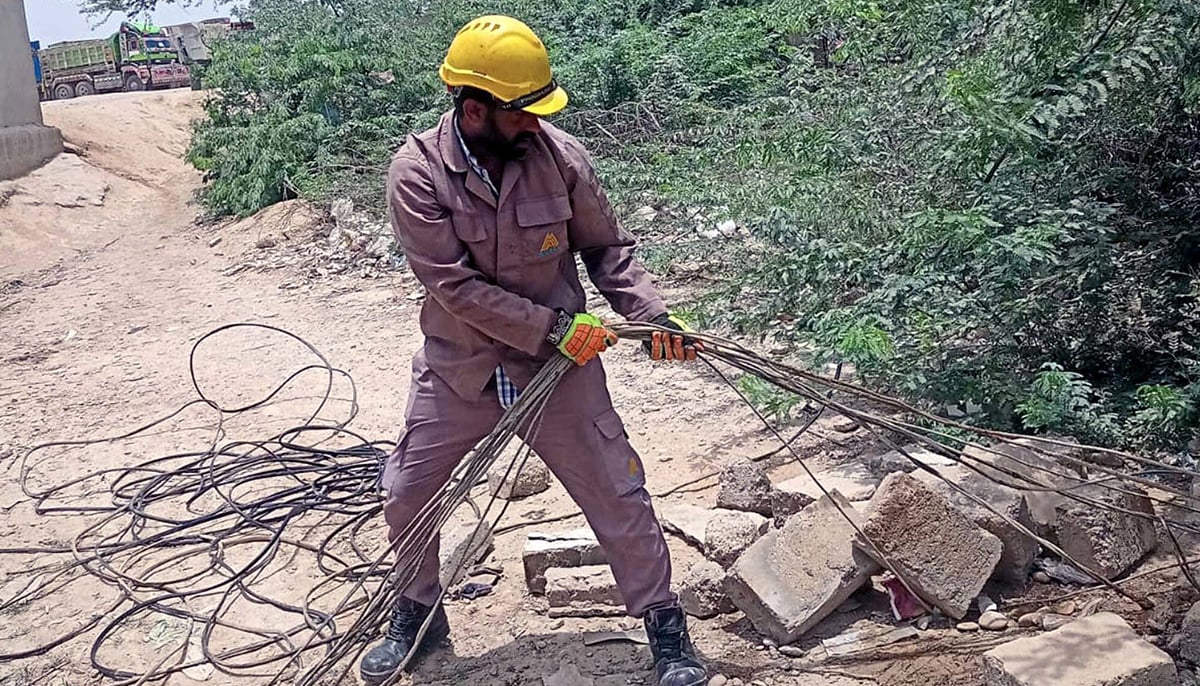 A KE worker disconnecting illegal electricity connections during a crackdown campaign against electricity theft, in Hub on Monday, August 4, 2025. — PPI