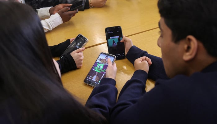 Students from Ricards Lodge and Rutlish High Schools in Wimbledon look at their mobile phones during an interview and discussion with Reuters about their thoughts on a social media ban for under 16s, in London, Britain, February 23, 2026. — Reuters