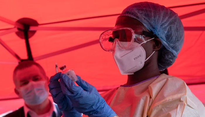 A nurse wearing protective medical clothing draws a dose from a vaccine vial during the launch of an Ebola trial vaccination campaign at Mulago Referral Hospital during a previous Ebola outbreak in Kampala, Uganda, on February 3, 2025. — AFP
