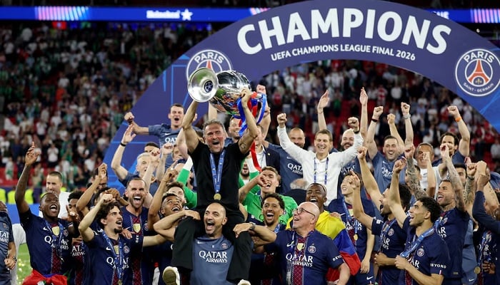 Paris Saint-Germain coach Luis Enrique holds the trophy as he celebrates with players and staff after winning the UEFA Champions League final against Arsenal at the Puskas Arena in Budapest, Hungary, May 30, 2026. — Reuters