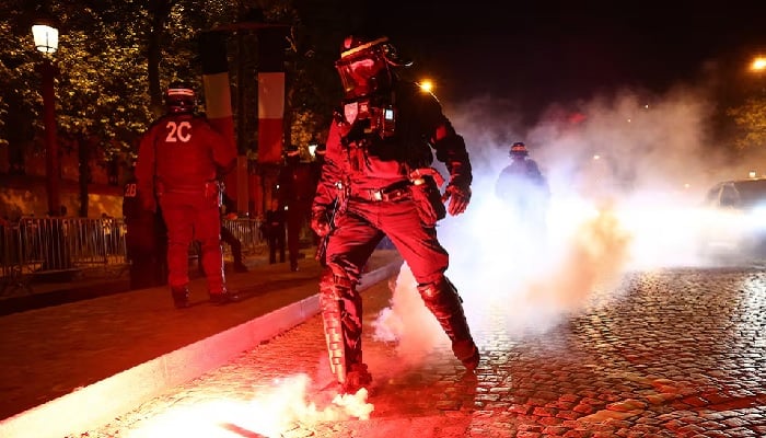 A police officer extinguishes a flare during celebrations by Paris Saint-Germain supporters near the Champs-Élysées after the club qualified for the UEFA Champions League final, in Paris, France, May 7, 2025.— Reuters