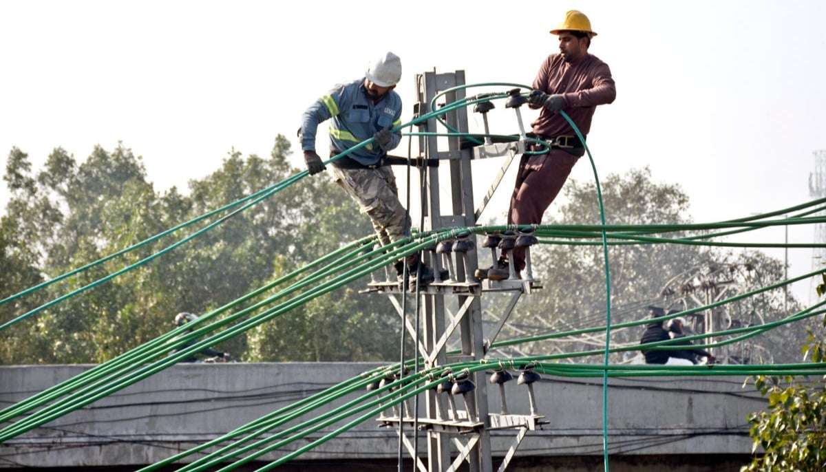 LESCO workers are repairing and laying new electrical wires on poles to restore power in Lahore on February 10, 2026. — APP