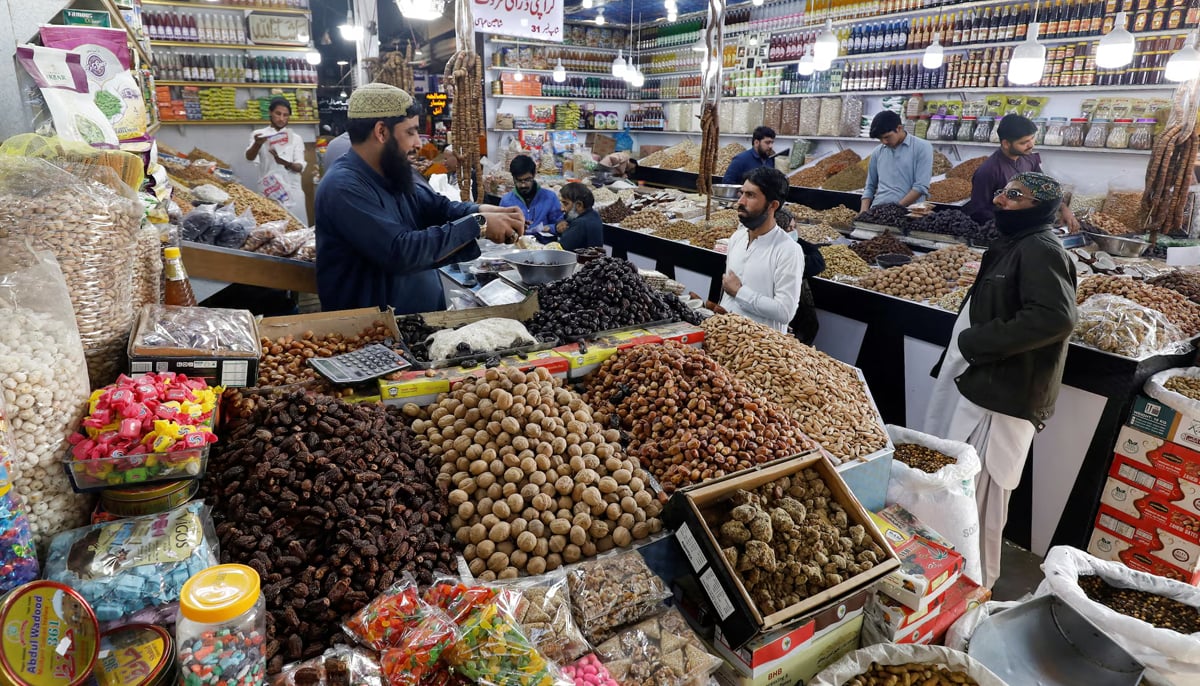 People buy dry fruits at a market in Karachi, on February 1, 2023. — Reuters